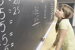 Girl at board doing math problems