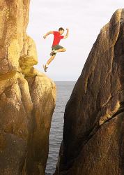 Boy leaping between rocks