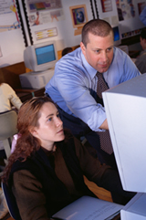Teacher helping child at computer