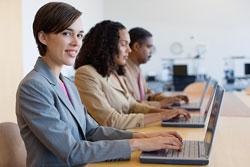 Row of people working with laptops