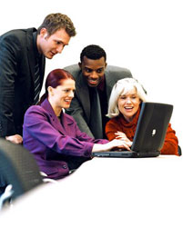 Four colleagues working together at laptop