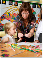Teacher helping student with an art project.