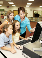 children and teacher at a computer