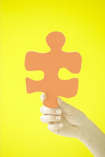 Child's hand holding an orange puzzle piece