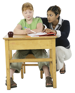 Teacher helping girl at her desk